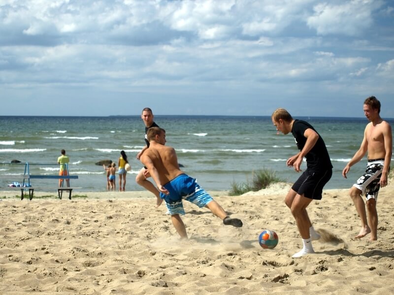 Neli meest mängimas rannaliival jalgpalli