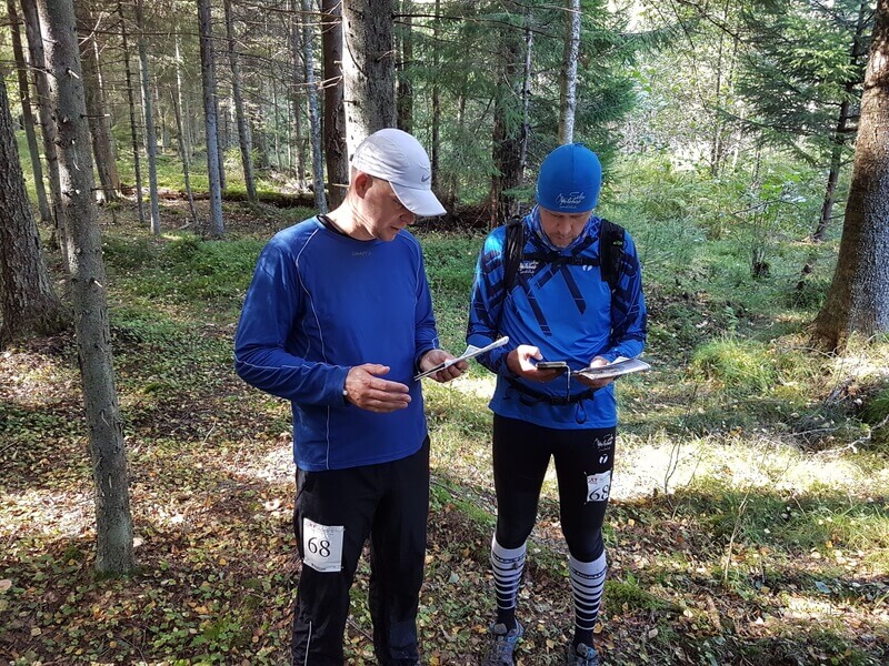 Kaks orienteerujat sügavas metsas arutlevad omavahel ja vaatavad kaarti