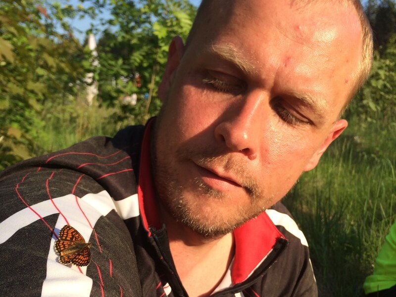 Mees jälgib malbel ilmel liblikat, kes on maandunud tema õlale