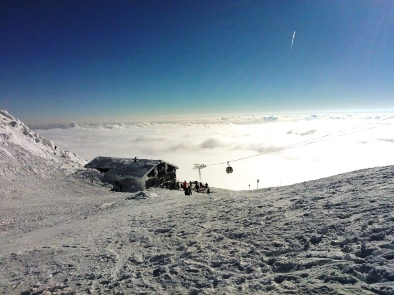 Härmas-lumine suusakohvik mägedes pealpool pilvi