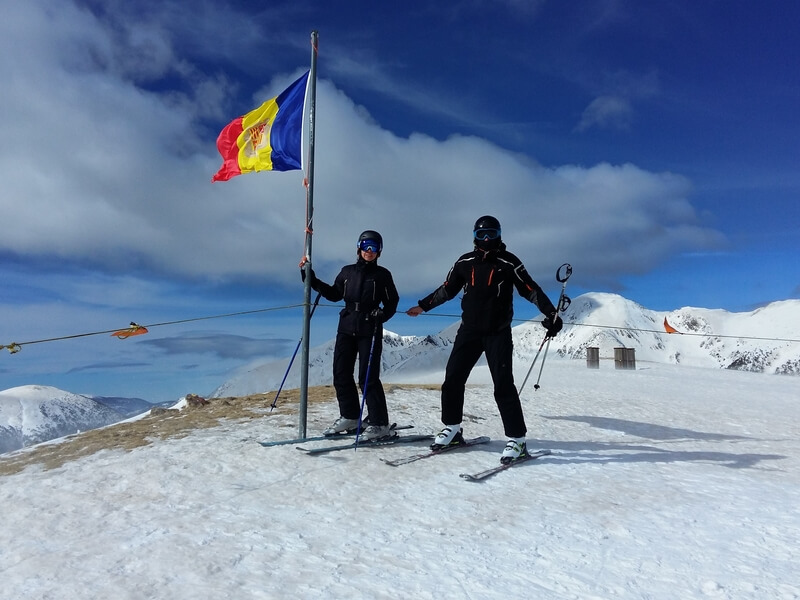 Kaks suusatajat on vallutanud mäetipu Andorras ja poseerivad lipu kõrval